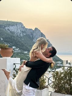 a man and woman embracing each other on a balcony