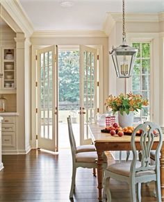 an image of a dining room with french doors and windows on the side of it