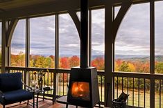 a living room with a fire place and large windows on the side of the house