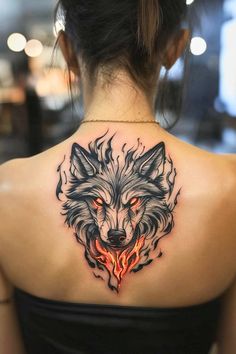 the back of a woman's shoulder with a wolf tattoo on it