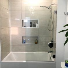 a bathroom with a shower, toilet and bathtub in the corner next to a potted plant