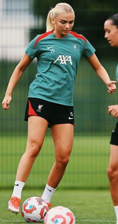 two women are playing soccer on the field