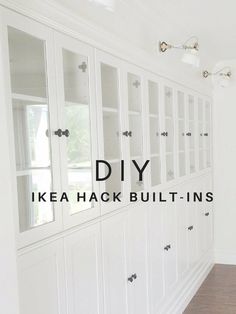 an empty room with white cabinets and wood flooring in the background is a large window that reads diy ikea hack built - ins