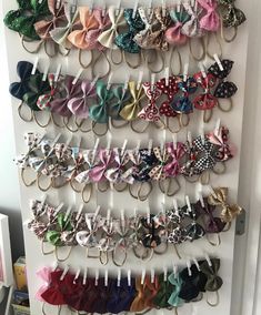 a bunch of small bows are hanging on a white wall in front of a door