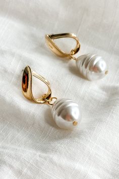 The Ellie Pearl & Gold Dangle Huggie Earrings, a fusion of classic elegance and contemporary charm. These enchanting earrings feature chic gold huggies adorned with delicate pearl attachments, exuding timeless sophistication with a modern twist. Crafted with precision and attention to detail, these earrings are designed to complement any ensemble, from casual chic to formal elegance. The lustrous pearls dangle gracefully from the huggies, adding a touch of refinement to the sleek gold setting. P Travel Dress, Style And Grace, Gold Pearl, Classic Elegance, Huggies Earrings, Earring Necklace, Ring Necklace, Everyday Look, Jewelry Sales