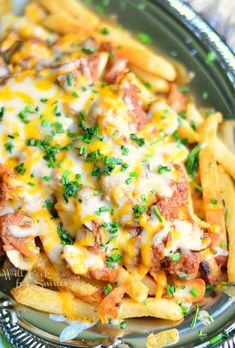 a close up of a plate of food with french fries and cheese on it,