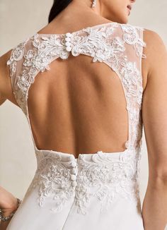 the back of a woman's wedding dress, with an intricate lace and beading