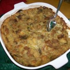 a casserole dish with meat and vegetables in it next to a glass of milk