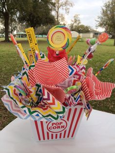 a paper bag filled with candy and candies on top of a table in a park