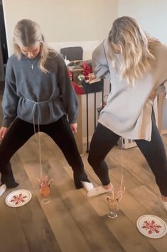 two women standing on top of a wooden floor