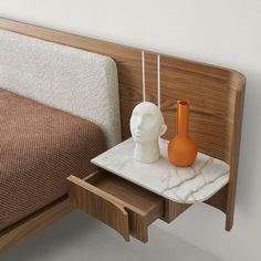 a bed with a wooden headboard and two vases sitting on it's side