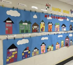 a bulletin board with houses and clouds on it in a classroom setting that says, super work my community