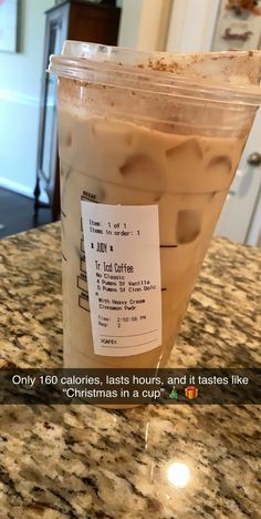 a cup of coffee sitting on top of a counter next to a sign that says, only 100 calories, tastes hours, and tastes like christmas in a cup