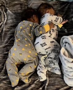 a small child sleeping on top of a bed next to pillows and blankets with writing on them