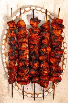 several skewers of meat sitting on top of a plate