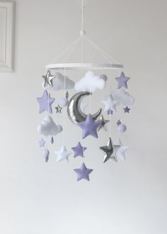 a baby crib mobile with stars, moon and clouds