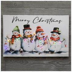 a christmas card with three snowmen wearing hats and scarves