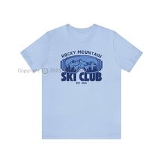 Introducing our exclusive Rocky Mountain Ski Club Graphic T-Shirt - the perfect fusion of comfort and style for winter lovers, skiing enthusiasts, and those who appreciate trendy apparel. Available in a variety of 10 vibrant colors, this T-shirt features a unique design on the front, showcasing the iconic Rocky Mountain ski club emblem, accompanied by a graphic of ski goggles and a stunning mountain landscape. Whether you're gearing up for a day on the slopes, embarking on an adventure, or simply enjoying a leisurely day at home, this unisex T-shirt is the ideal choice. Its versatile fit ensures a comfortable and relaxed feel, allowing you to express your passion for winter and the Rocky Mountains effortlessly. Crafted to cater to your individual style, this T-shirt offers the perfect canv Sporty Tops With Logo Print For Outdoor, Sporty Blue T-shirt For Outdoor Activities, Winter Relaxed Fit T-shirt With Logo Print, Sporty T-shirt With Logo For Outdoor Activities, Sporty Logo Print T-shirt For Outdoor Activities, Sporty Graphic Print T-shirt For Outdoor Activities, Blue T-shirt For Winter Sports, Winter Outdoor T-shirt With Relaxed Fit, Sporty Graphic Print Winter T-shirt