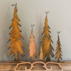 three metal trees are sitting on top of a mantle