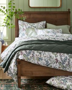 a bedroom with green walls and wooden bed frame