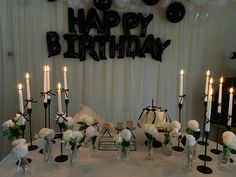 a birthday party with candles and flowers on the table