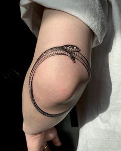 a woman's arm with a snake tattoo on it