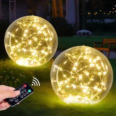 two glowing balls with remote controls in the grass