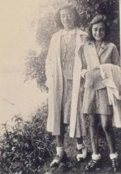 an old photo of two women standing next to each other