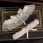 two wedding garters are sitting on top of a black book with gold trim