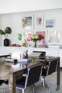 a table with chairs and pictures on the wall