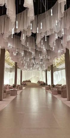 a large room filled with lots of white cloths hanging from the ceiling