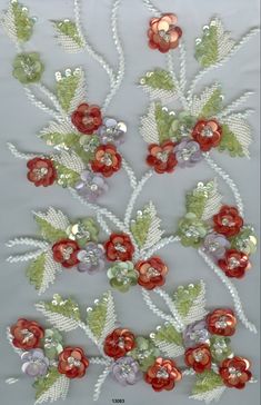 an image of some flowers on a white surface with beads and sequins in the middle