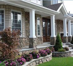 a house with stone steps and landscaping around it