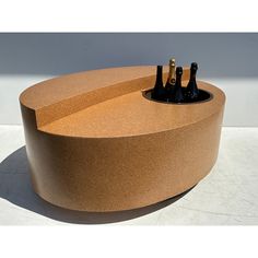 three bottles are placed in the center of a circular table that is made out of cork