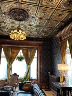 a living room filled with furniture and a chandelier hanging from it's ceiling