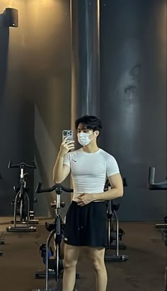 a woman wearing a face mask while standing in a gym