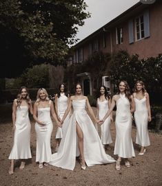 a group of women in white dresses standing next to each other