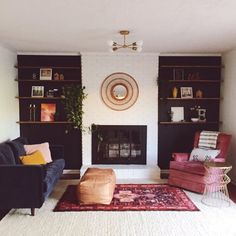 a living room with two couches and a rug in front of the fire place