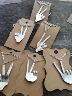 six pieces of silverware are arranged on top of brown tags with chains attached to them