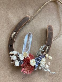 an old horseshoe with flowers and crystals on it