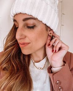 a woman wearing a white hat while talking on a cell phone