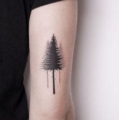 a small pine tree tattoo on the arm