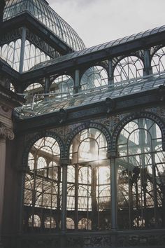 the inside of a building with many windows and arches on each side, looking up at the sky