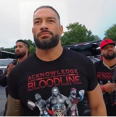 a man in a black shirt standing next to other men