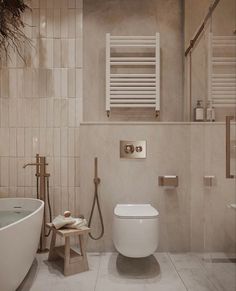 a white toilet sitting next to a bath tub in a bathroom under a heater