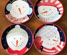 four plates with snowmen painted on them