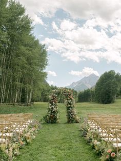 an outdoor ceremony setup with flowers and greenery