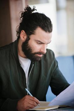 a man sitting at a table with a pen and paper