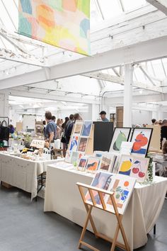 people looking at art on tables in an open room