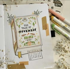 an open notebook with the words the tales of november written on it next to some markers and pencils